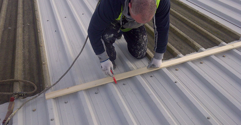 IRM roofing expert wearing a safety harness