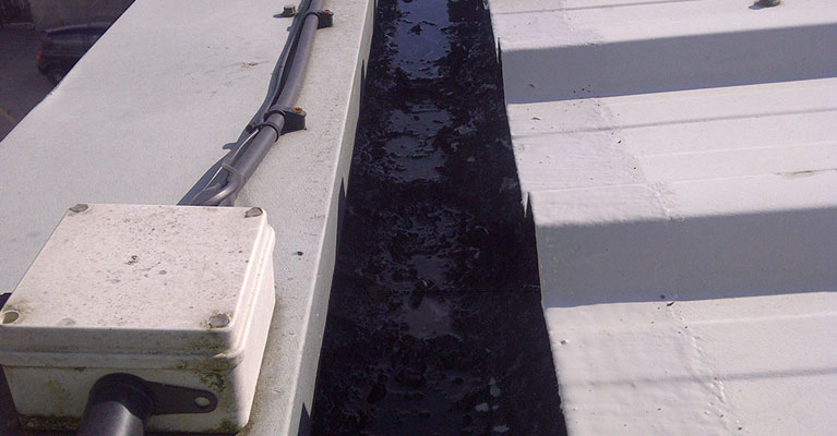 Industrial roof gutter before being cleaned