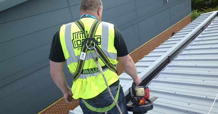 Cut edge corrosion expert using a leaf blower to dry off excess rainwater