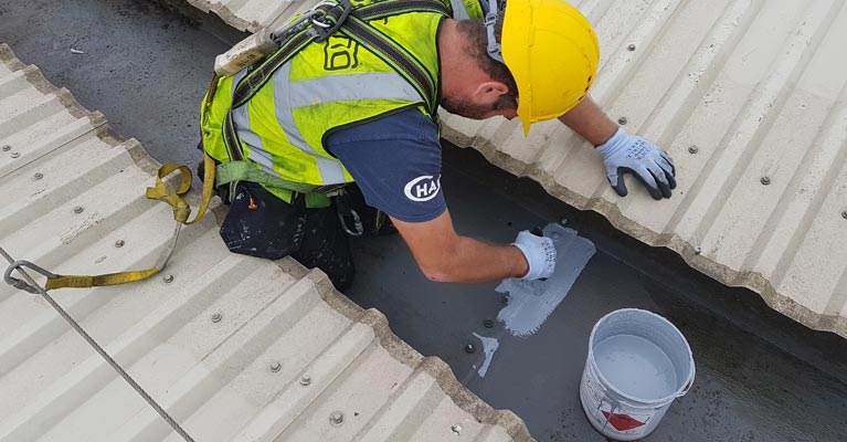 IRM Roofing approved Giromax installer brush applying Seamsil 300.