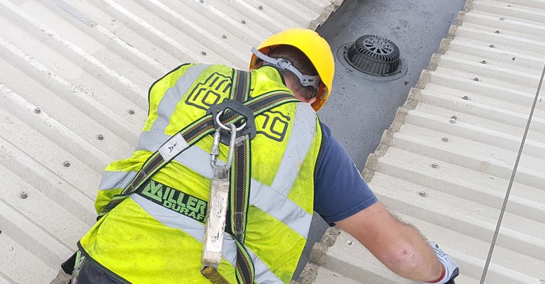 IRM Roofing operative clipped onto existing safety line whilst working on the roof.