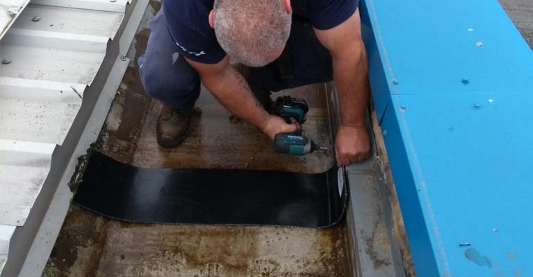 Plygene installer fixing a joint protection strip into position.