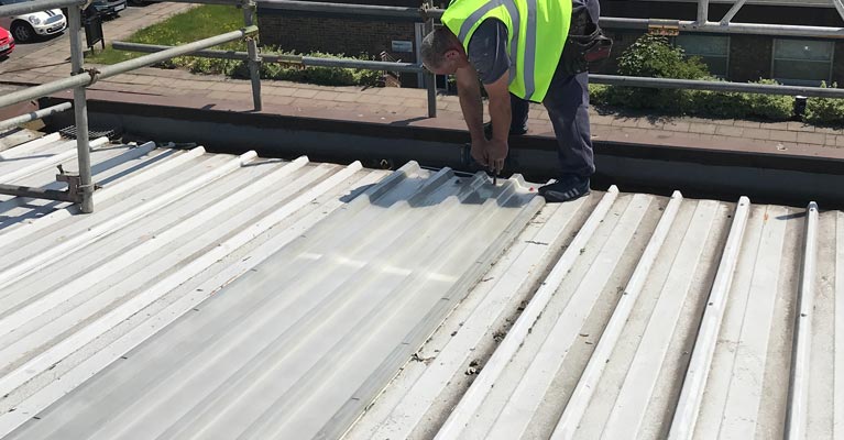 GRP roof light installer fixing down the outer skin.